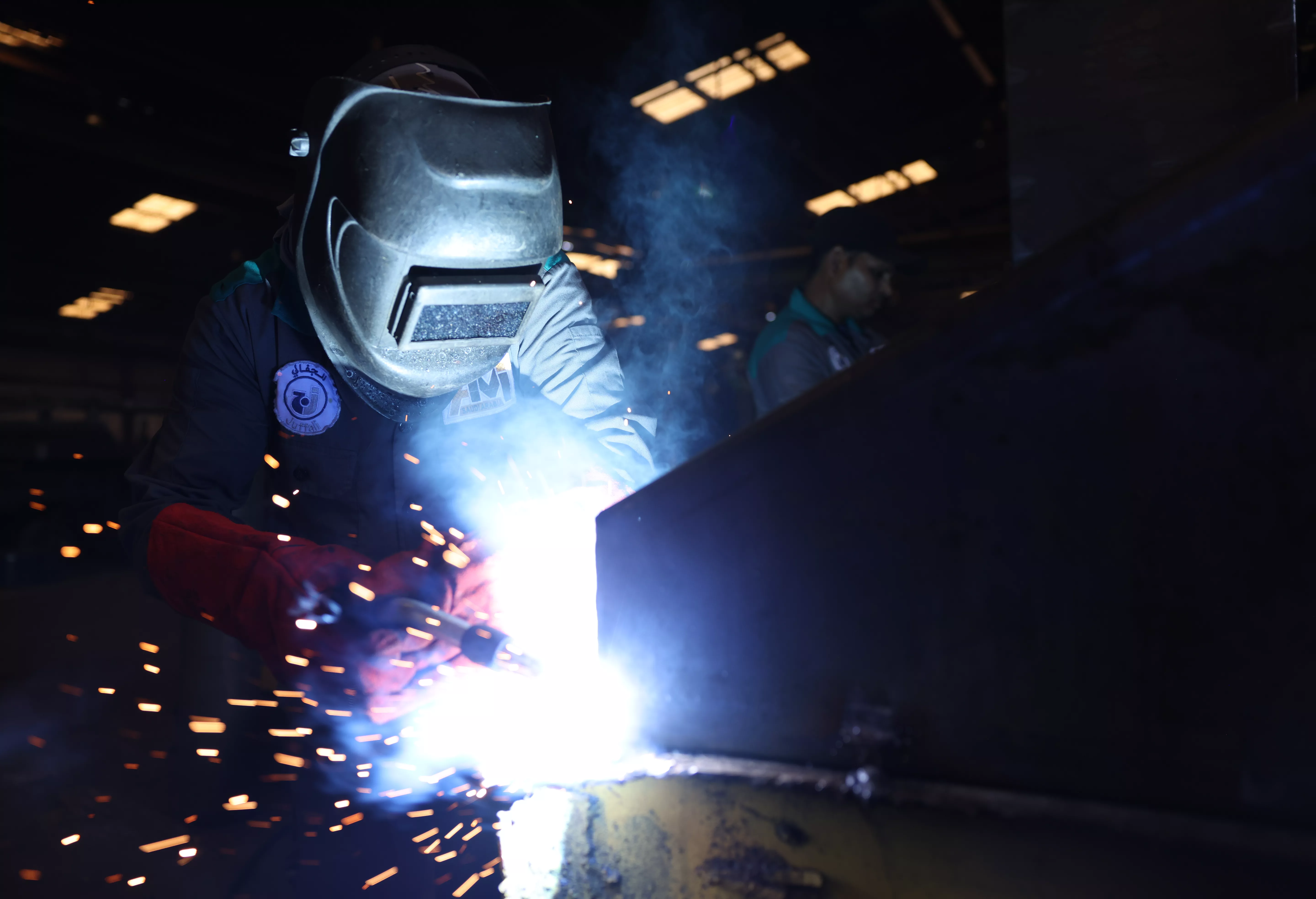 AMI factory worker welding steel truck body parts